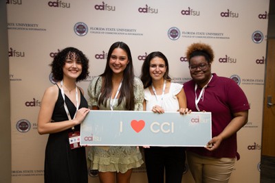 CCI students holding "I (heart emoji) CCI" sign.